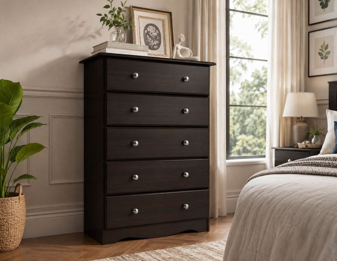 A tall dark brown espresso wooden five-drawer dresser in a styled bedroom setting, featuring silver knobs and decorative items on top.