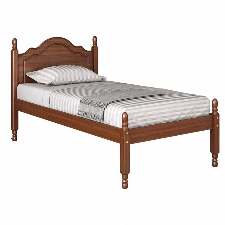 A wooden mocha brown colored twin bed frame with a curved headboard and turned legs on a white background.