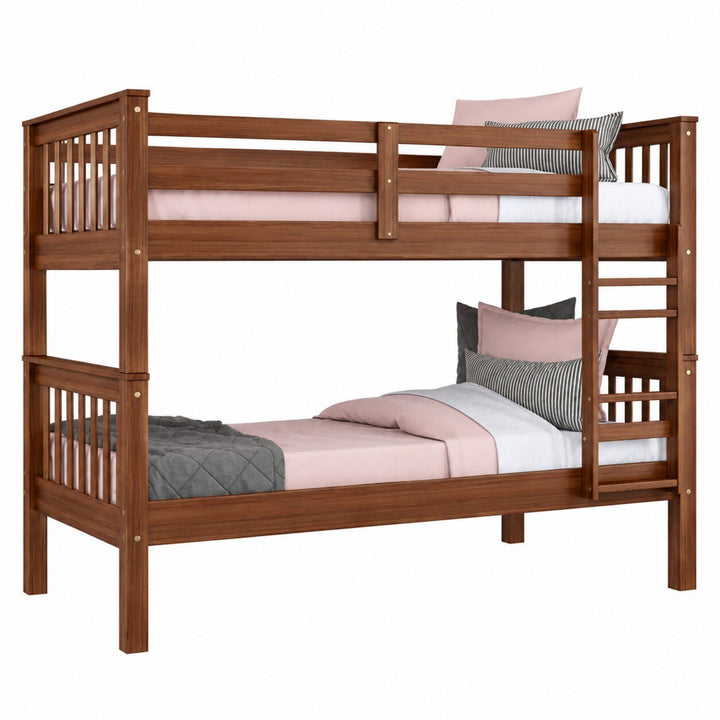 A wooden bunk bed with a warm brown finish, featuring safety rails on the top and bottom, an integrated ladder on the right, and styled with pink and gray bedding against a solid white background.